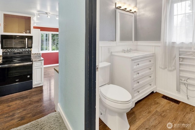 8597 Harborview Rd, Blaine, WA 98230 - bathroom featuring wood finished floors, a wainscoted wall, and vanity