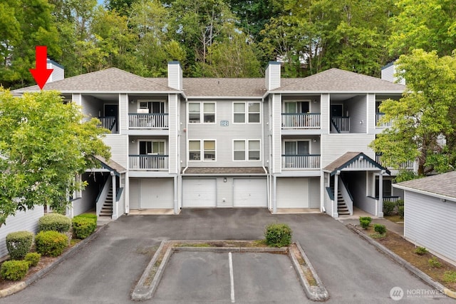 33020 10th Ave SW Unit 301, Federal Way, WA 98023 - view of property with stairway, driveway, a garage, and view of scattered trees
