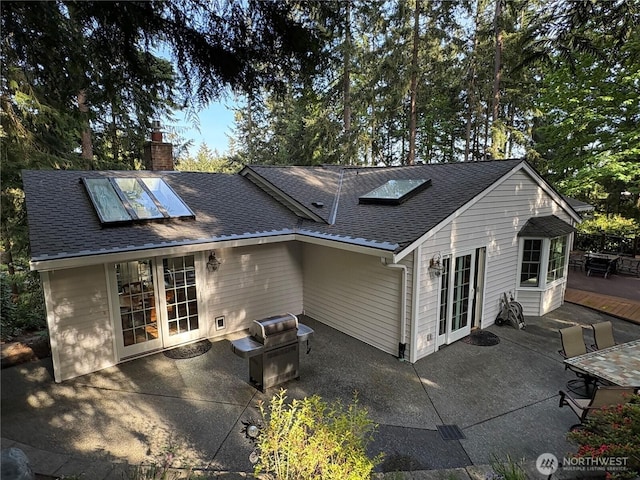 12810 NE 32nd Pl, Bellevue, WA 98005 - rear view of house featuring french doors, roof with shingles, a patio area, and a chimney