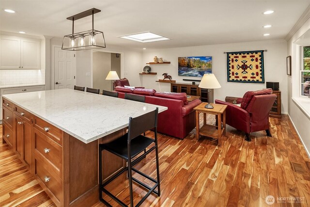 12810 NE 32nd Pl, Bellevue, WA 98005 - kitchen featuring light wood-style floors, open floor plan, a breakfast bar area, recessed lighting, and decorative backsplash