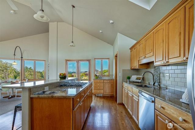 8705 Fenwick Loop SE, Olympia, WA 98513 - kitchen featuring appliances with stainless steel finishes, high vaulted ceiling, stone countertops, wood finished floors, and a kitchen bar