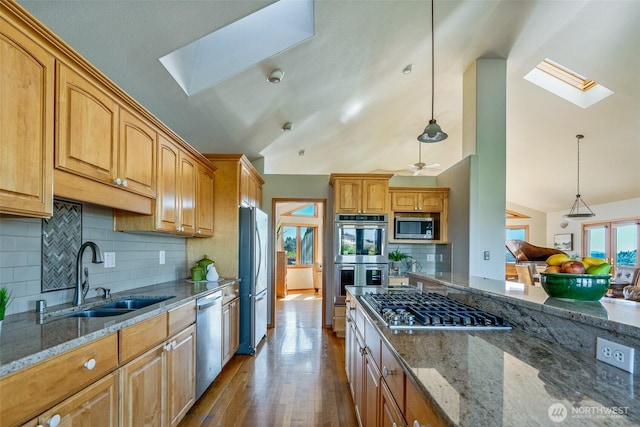 8705 Fenwick Loop SE, Olympia, WA 98513 - kitchen featuring a skylight, appliances with stainless steel finishes, stone counters, vaulted ceiling, and dark wood-style flooring