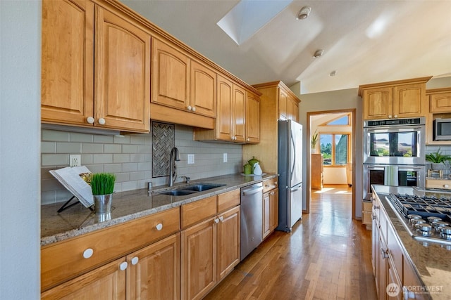 8705 Fenwick Loop SE, Olympia, WA 98513 - kitchen featuring stainless steel appliances, light stone countertops, wood finished floors, decorative backsplash, and brown cabinets