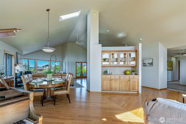 8705 Fenwick Loop SE, Olympia, WA 98513 - dining room with light wood-style flooring, high vaulted ceiling, a skylight, and ceiling fan