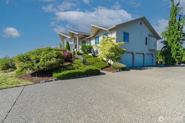 8705 Fenwick Loop SE, Olympia, WA 98513 - view of front of property featuring an attached garage, asphalt driveway, and stucco siding