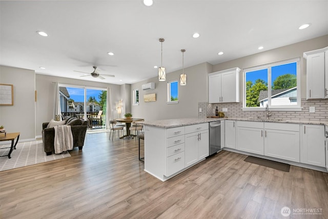 5690 Sunstone Pl Unit 101, Ferndale, WA 98248 - kitchen with a peninsula, stainless steel dishwasher, open floor plan, light wood-style floors, and recessed lighting