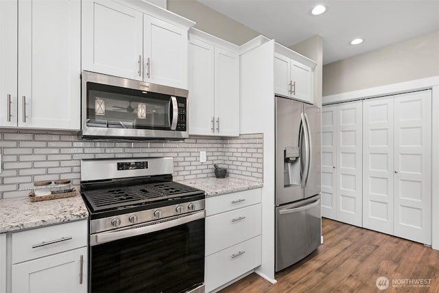 5690 Sunstone Pl Unit 101, Ferndale, WA 98248 - kitchen featuring appliances with stainless steel finishes, white cabinetry, decorative backsplash, and recessed lighting