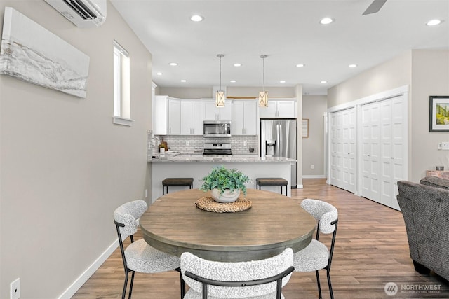 5690 Sunstone Pl Unit 101, Ferndale, WA 98248 - dining area featuring recessed lighting, a wall mounted air conditioner, light wood finished floors, and a ceiling fan