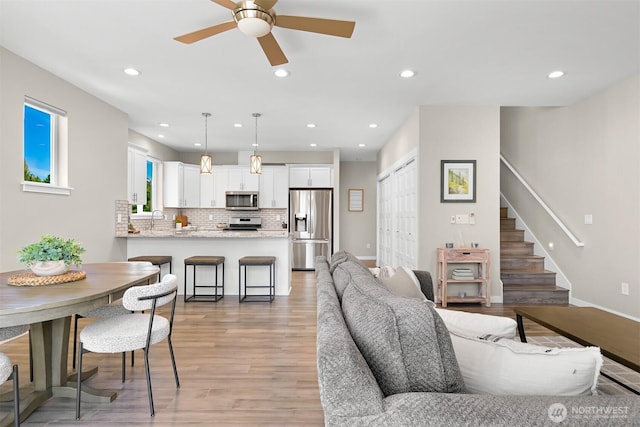 5690 Sunstone Pl Unit 101, Ferndale, WA 98248 - living area with light wood finished floors, ceiling fan, stairway, and recessed lighting