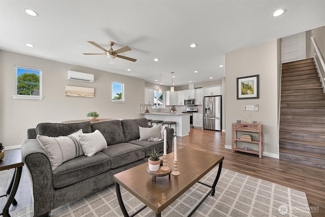 5690 Sunstone Pl Unit 101, Ferndale, WA 98248 - living area featuring a wall mounted air conditioner, healthy amount of natural light, a ceiling fan, stairway, and recessed lighting