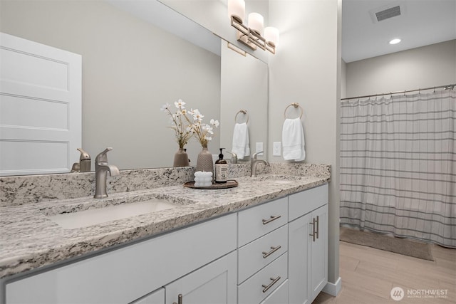 5690 Sunstone Pl Unit 101, Ferndale, WA 98248 - bathroom with double vanity, wood finished floors, and recessed lighting