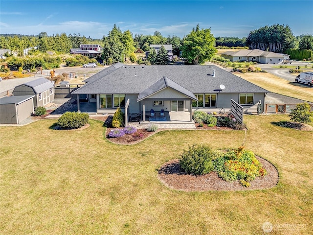 73 Sable Ct, Sequim, WA 98382 - back of property featuring a yard, a storage shed, a patio, and roof with shingles