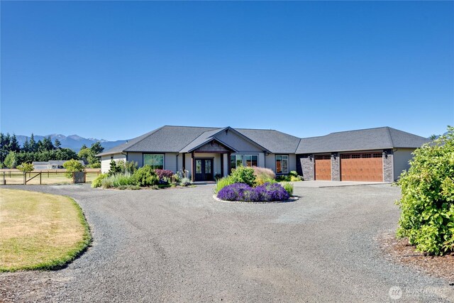 73 Sable Ct, Sequim, WA 98382 - view of front of house featuring french doors, a garage, gravel driveway, and a mountain view