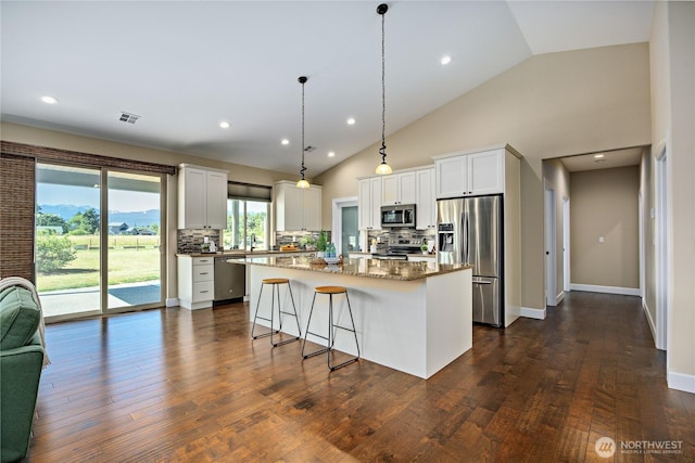 73 Sable Ct, Sequim, WA 98382 - kitchen with stainless steel appliances, vaulted ceiling, tasteful backsplash, a center island, and white cabinets