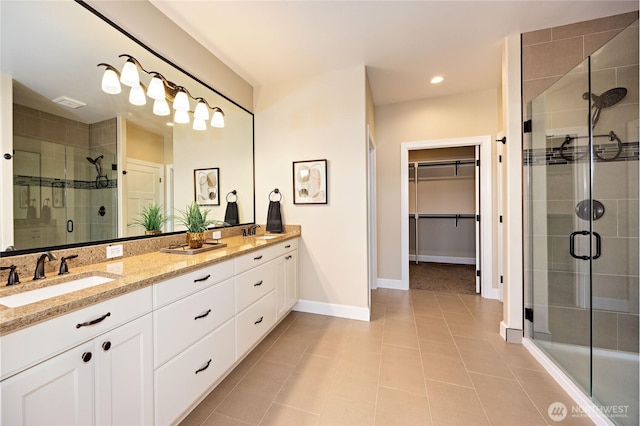 73 Sable Ct, Sequim, WA 98382 - bathroom featuring double vanity, a stall shower, a spacious closet, tile patterned flooring, and recessed lighting