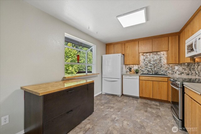 14416 4th Ave E, Tacoma, WA 98445 - kitchen featuring white appliances, tasteful backsplash, stone finish floors, butcher block countertops, and brown cabinetry