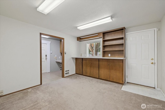 14416 4th Ave E, Tacoma, WA 98445 - kitchen featuring light carpet, brown cabinets, light countertops, and open shelves