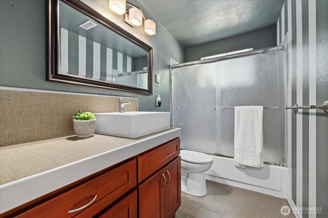 14416 4th Ave E, Tacoma, WA 98445 - full bathroom with vanity, bath / shower combo with glass door, and a textured ceiling