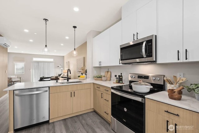 14707 87th Ave SE Unit V4, Snohomish, WA 98296 - kitchen with appliances with stainless steel finishes, a peninsula, a wall mounted air conditioner, light brown cabinetry, and light wood finished floors