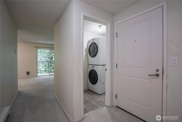 230 SW Clark St Unit C203, Issaquah, WA 98207 - laundry room featuring stacked washer and clothes dryer, light colored carpet, and a textured ceiling