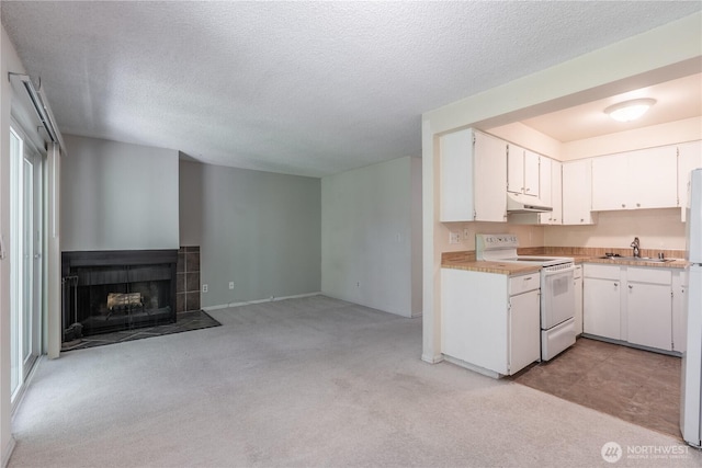 230 SW Clark St Unit C203, Issaquah, WA 98207 - kitchen with white range with electric stovetop, under cabinet range hood, light countertops, light colored carpet, and white cabinets
