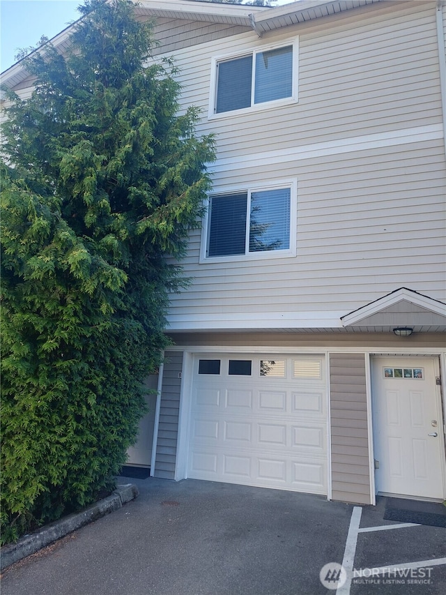 6907 Rainier Dr E Unit 1B, Everett, WA 98203 - view of side of property featuring a garage