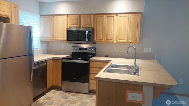 6907 Rainier Dr E Unit 1B, Everett, WA 98203 - kitchen with stainless steel appliances, a peninsula, light brown cabinetry, and light countertops