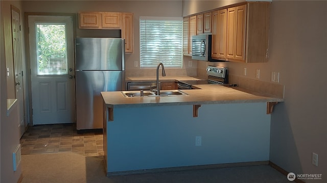 6907 Rainier Dr E Unit 1B, Everett, WA 98203 - kitchen featuring appliances with stainless steel finishes, healthy amount of natural light, a kitchen bar, and a peninsula
