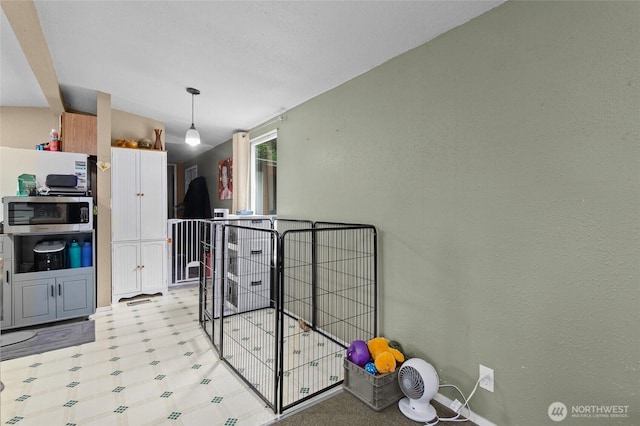 22517 133rd Street Ct E, Orting, WA 98360 - kitchen with stainless steel microwave, light flooring, and lofted ceiling