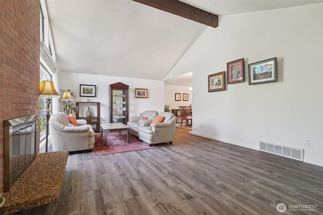 32710 5th Ave SW, Federal Way, WA 98023 - living room featuring wood finished floors, beam ceiling, high vaulted ceiling, a textured ceiling, and a brick fireplace
