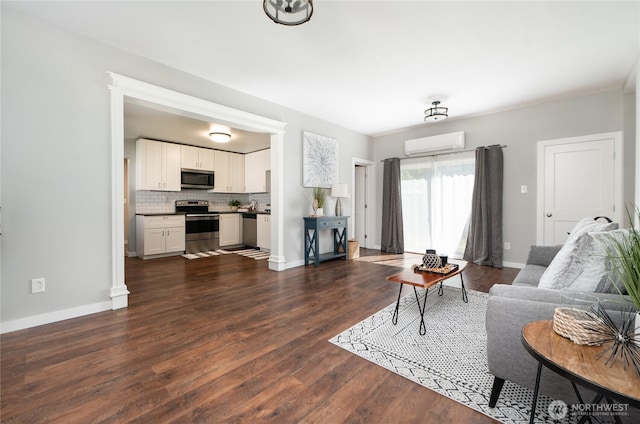 462 G St, Blaine, WA 98230 - living area featuring a wall unit AC and dark wood finished floors