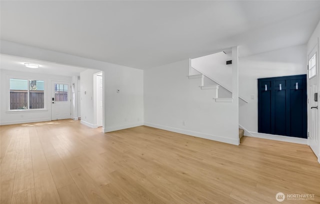 1717 150th Ave SE Unit 18, Bellevue, WA 98007 - unfurnished living room featuring stairway, light wood-type flooring, and healthy amount of natural light