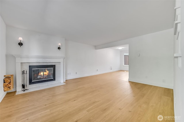 1717 150th Ave SE Unit 18, Bellevue, WA 98007 - unfurnished living room featuring a tiled fireplace and wood finished floors