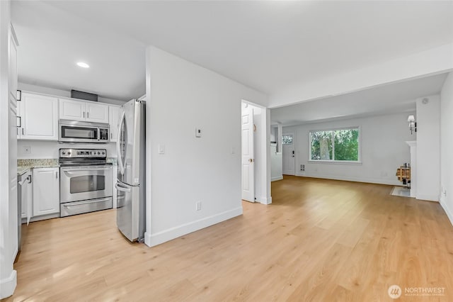 1717 150th Ave SE Unit 18, Bellevue, WA 98007 - kitchen featuring stainless steel appliances, white cabinetry, open floor plan, light wood-type flooring, and recessed lighting