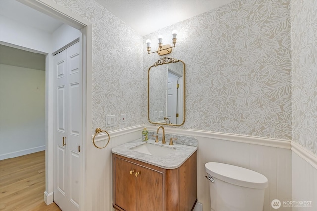 1717 150th Ave SE Unit 18, Bellevue, WA 98007 - bathroom with wallpapered walls, a wainscoted wall, wood finished floors, and vanity