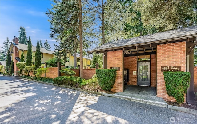 1717 150th Ave SE Unit 18, Bellevue, WA 98007 - view of exterior entry featuring brick siding and a shingled roof