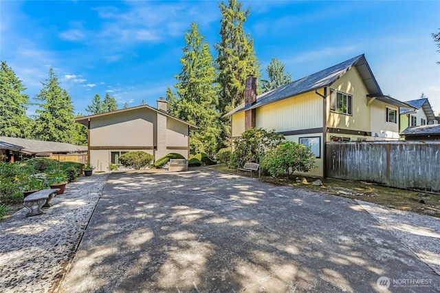 1717 150th Ave SE Unit 18, Bellevue, WA 98007 - view of home's exterior featuring driveway, a chimney, and a carport