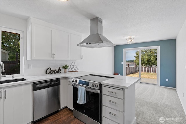 2235 E Wright Ave, Tacoma, WA 98404 - kitchen with appliances with stainless steel finishes, exhaust hood, a peninsula, light stone counters, and white cabinets