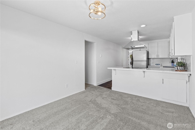 2235 E Wright Ave, Tacoma, WA 98404 - kitchen featuring range hood, freestanding refrigerator, dark carpet, a peninsula, and white cabinets