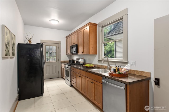 743 Broadway E, Seattle, WA 98102 - kitchen with black appliances, dark countertops, brown cabinets, and light tile patterned floors