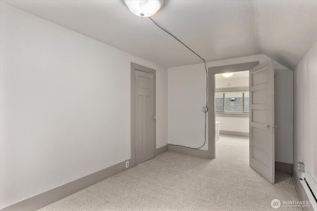 743 Broadway E, Seattle, WA 98102 - unfurnished bedroom with light carpet, a baseboard radiator, and vaulted ceiling