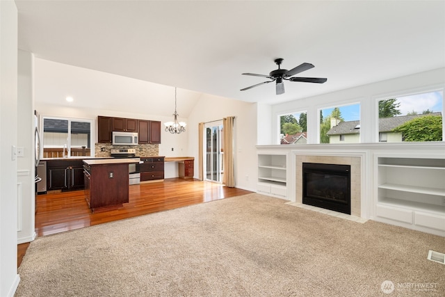 20122 102nd Ave SE, Kent, WA 98031 - unfurnished living room with carpet, a chandelier, a tiled fireplace, ceiling fan, and lofted ceiling