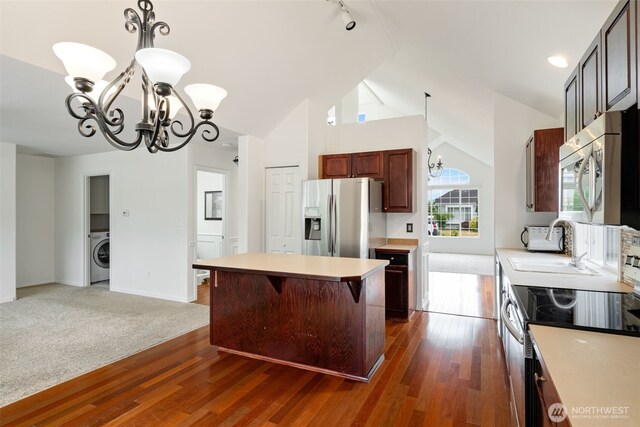 20122 102nd Ave SE, Kent, WA 98031 - kitchen with a chandelier, appliances with stainless steel finishes, washer / clothes dryer, lofted ceiling, and light countertops