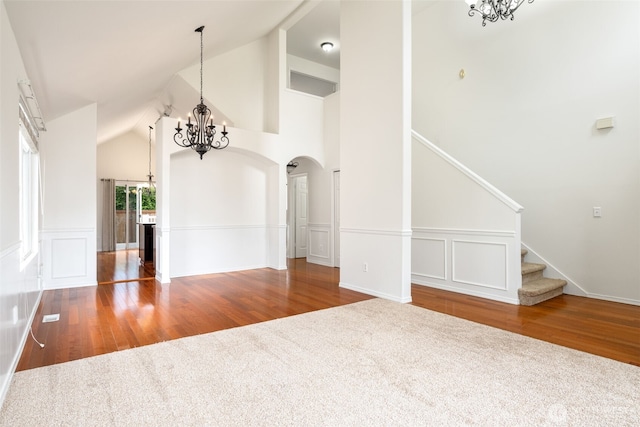 20122 102nd Ave SE, Kent, WA 98031 - unfurnished living room featuring a chandelier, wood finished floors, arched walkways, a wainscoted wall, and a decorative wall