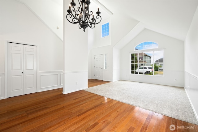 20122 102nd Ave SE, Kent, WA 98031 - unfurnished living room with a chandelier, high vaulted ceiling, wainscoting, and wood finished floors