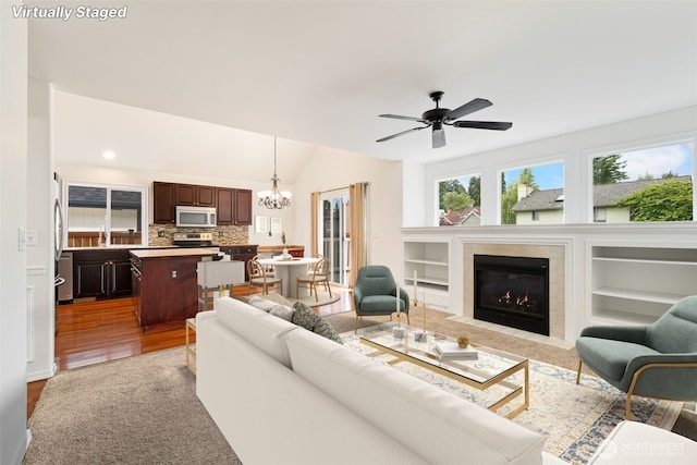 20122 102nd Ave SE, Kent, WA 98031 - living area with a chandelier, plenty of natural light, a fireplace, wood finished floors, and lofted ceiling