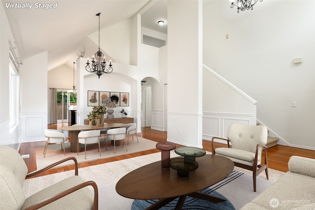 20122 102nd Ave SE, Kent, WA 98031 - living area with a chandelier, arched walkways, wood finished floors, a decorative wall, and high vaulted ceiling