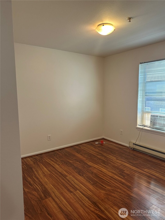 10511 Midvale Ave N Unit 202, Seattle, WA 98133 - spare room featuring dark wood-style flooring, a baseboard radiator, and a pendent fire sprinkler