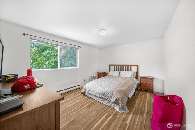 11556 Greenwood Ave N Unit 105, Seattle, WA 98133 - bedroom with a baseboard heating unit and light wood-type flooring