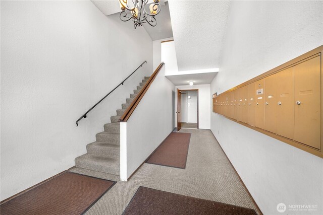 11556 Greenwood Ave N Unit 105, Seattle, WA 98133 - carpeted entryway with mail area, stairs, and a chandelier